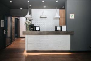 a lobby with a counter with pendant lights at Coffee Fellows Hotel München-Freiham in Munich