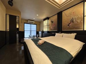 un cane sdraiato su un letto in una camera da letto di Hotel MGM a Niigata