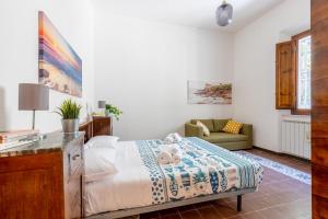 un dormitorio con una cama y un sofá en GuestHost - Cozy Country Apartment, en Vicopisano