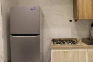 a kitchen with a stainless steel refrigerator and a stove at شقق العامر in Jeddah +39 photos