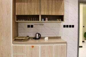 a kitchen with wooden cabinets and a counter top at شقق العامر in Jeddah