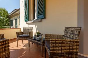 un patio con sillas, una mesa y una ventana en GuestHost - Cozy Country Apartment, en Vicopisano