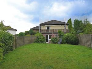 a house with a fence in a yard at Garden-view Apartment in Heringhausen Lake City Centre in Heringhausen