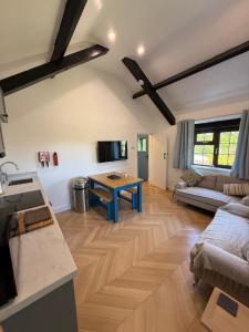 a kitchen and living room with a couch and a table at Cornflower in Saundersfoot