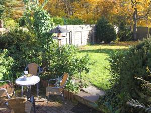 a patio with a table and chairs in a garden at Garden-view Apartment in Heringhausen Lake City Centre in Heringhausen