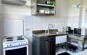 a kitchen with a sink and a stove at BEGE APARTMENTS HomeAway in Marl