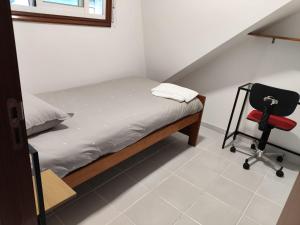 a small bedroom with a bed and a chair at Casa PEPE in Combarro