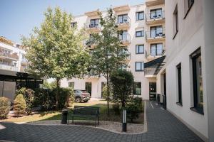 a bench on a sidewalk in front of a building at Coffee Fellows Hotel München-Freiham in Munich