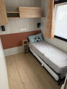 Un dormitorio pequeño con una cama y una ventana. en Mobilhome Cap'Oceha SIBLU-Les Viviers 4étoiles, en Lège-Cap-Ferret