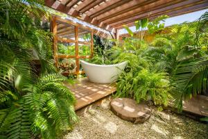 a garden with a bath tub surrounded by plants at Oceanfront Villa with Overwater Deck in Savaneta +34 photos