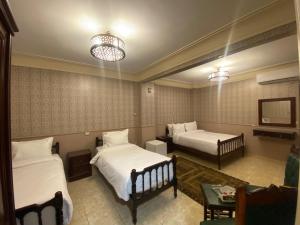 ein Hotelzimmer mit zwei Betten und einem Tisch in der Unterkunft ALRashedy Hotel Powered by Boutique in Kairo + 79 Fotos