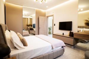 ein Schlafzimmer mit Bett und Flachbildfernseher in der Unterkunft TReverie Stay -Modern 3BR Apartment for Families & Friends in Thessaloniki