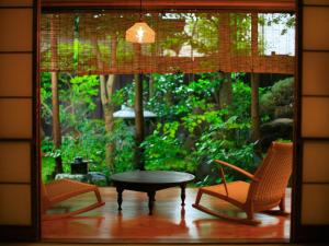 a room with two chairs and a table and a window at Hanakanzashi in Nihommatsu