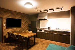 a kitchen and dining room with a table and a sink at ファーストアベニューハウス 駅近 1組限定貸切 in Anan