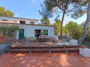 Un patio con mesa y sillas y una casa. en Sun & Sand Sanctuary - 2km to beach and 20km BCN!, en Castelldefels