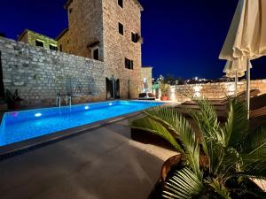 a swimming pool in front of a building at night at Hotel Palata Venezia in Ulcinj