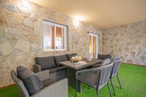 sala de estar con mesa, sillas y pared de piedra en Living Costa del sol Mijas, en Mijas Costa