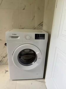 a white washing machine sitting in a bathroom at Cute Apartment at city center in Tirana