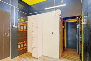a room with a clock on the wall and a door at Hotel O Mo Kudia in Brahmapur