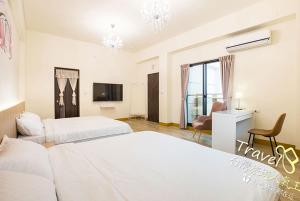 a hotel room with two beds and a television at 東華晴空樹民宿 in Shoufeng