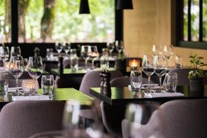 een groep wijnglazen op tafels in een restaurant bij Hotel Arc-en-ciel Gstaad in Gstaad