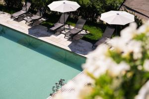 een uitzicht over een zwembad met stoelen en parasols bij Hotel Arc-en-ciel Gstaad in Gstaad