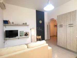 トッレ・ヴァードにあるCasa IBISCUS ROBERTAの白いソファとテレビのあるリビングルーム