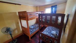 two bunk beds in a room with a fan at Unit 302, 3rd Floor in Baguio