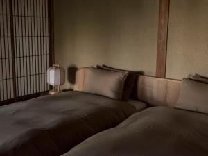 two beds in a room with a lamp on a table at 回青橙 daidai in Atami