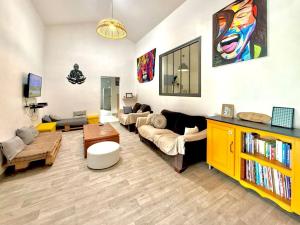 a living room with couches and a yellow cabinet at Case Hermione – Vue Montagne à Hell-Bourg in Salazie