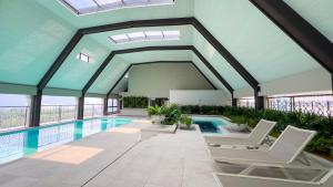 a house with a swimming pool with chairs and a swimming pool at Paxtonz Suite Damansara by Light House in Kuala Lumpur
