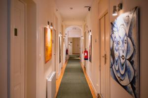 a corridor in a building with paintings on the walls at Casa do Bairro by Shiadu in Lisbon