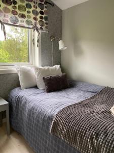 a bedroom with a bed with a blue comforter and a window at Cozy cottage on horse farm in Bollnäs in Bollnäs