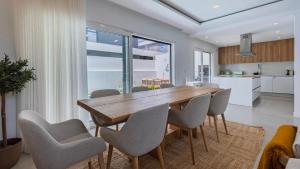 eine Küche und ein Esszimmer mit einem Holztisch und Stühlen in der Unterkunft Villa Aroeira with Pool by LovelyStay in Aroeira