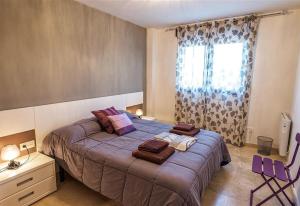 a bedroom with a bed with purple sheets and a window at Casa Rural la Montana 1 in Chella +30 photos