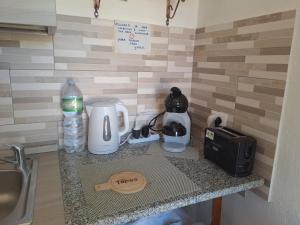 a kitchen counter with a coffee maker and a blender at B&B li salcuneddi in Aglientu