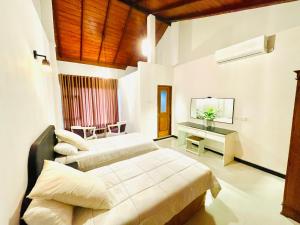 a bedroom with two beds and a desk in it at Heavenly Horizon Villa in Kandy