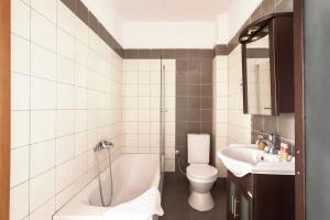 a bathroom with a tub and a toilet and a sink at Afitos deluxe home in Afitos
