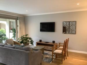 a living room with a couch and a table at Apartment Franschhoek 121 Lermitage in Franschhoek