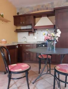 a kitchen with a table with chairs and a vase of flowers at appartamento luxury lavitabella in centro in La Spezia