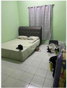 a bedroom with a bed and a tiled floor at Comfy Transit in Tawau +7 photos