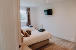 ein Schlafzimmer mit zwei Betten und einem Fenster in der Unterkunft Charming Dual - Cottage A Private Modern Retreat in Llanarthney