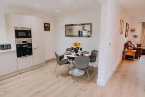 eine Küche und ein Esszimmer mit Tisch und Stühlen in der Unterkunft Charming Dual - Cottage A Private Modern Retreat in Llanarthney