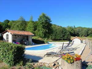 a swimming pool with a house and chairs next to it at Very nice cottage with studio on a domain with heated pool in Roussines +168 photos