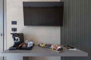 a table with food and a television on a wall at Bed & Mare by Perle di Puglia in Baia Di Gallipoli