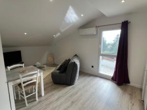 ein Wohnzimmer mit einer Couch und einem Tisch und einem Fenster in der Unterkunft Mons resort in Le Puy en Velay