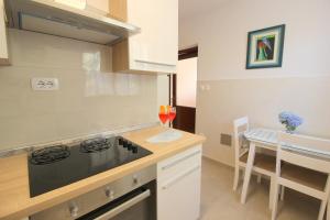 a kitchen with a stove and a table with a glass of wine at Lisa 2 near the beach in Novigrad Istria
