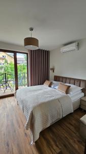 a bedroom with a large bed and a balcony at Willa Zacisze Szczawnica 15 m2 in Szczawnica +28 photos