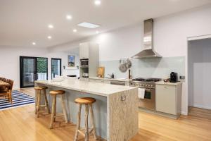 ポートシーにあるPortsea Coastal Retreatのバースツール付きの大きな島のあるキッチンが備わります。