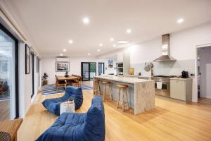 ポートシーにあるPortsea Coastal Retreatの大きなキッチンと青いソファのあるリビングルーム